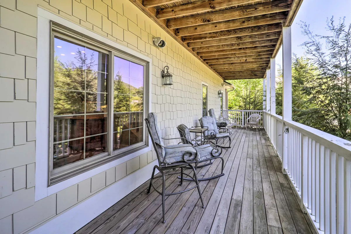 A welcoming porch featuring rocking chairs and a wooden railing, with views through a nearby window. This inviting space encourages relaxation and quiet reflection after a day of exploring the town's shops, galleries, and eateries.