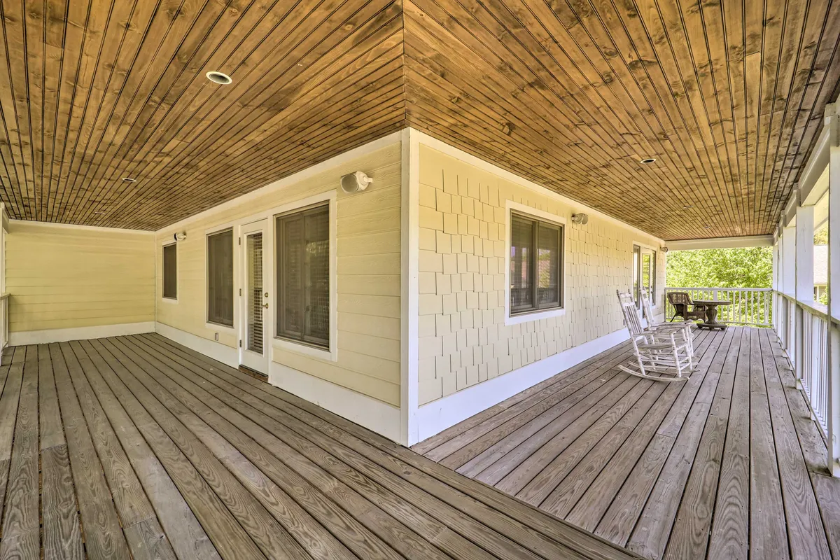 This image shows a serene wooden deck with classic rocking chairs facing outward, framed by a textured wall. The setup invites guests to relax outdoors, enjoy quiet conversations, or take in the peaceful surroundings after exploring downtown.
